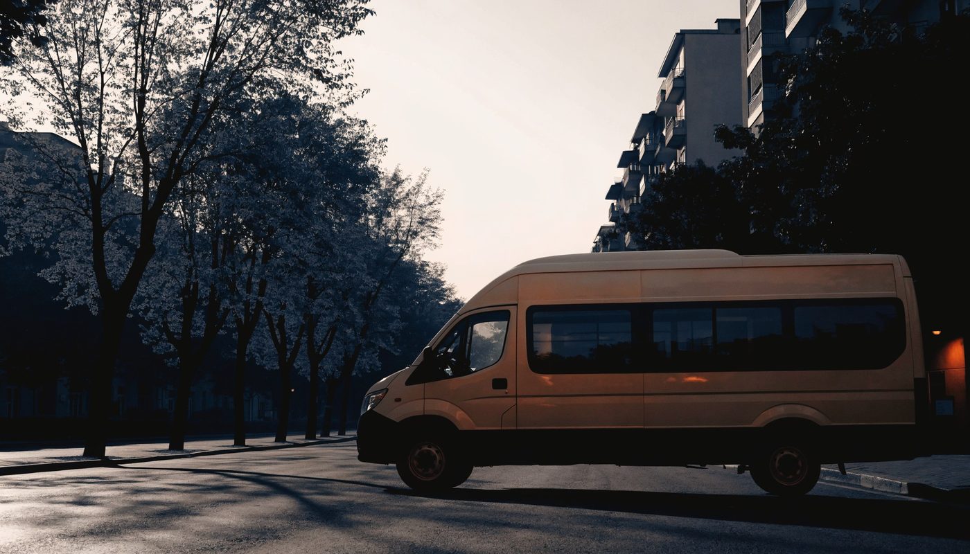 Öğrenci servis minibüsü ağaçlı sokakta